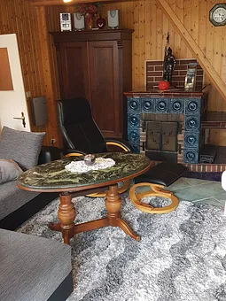 Hier schaut man von der Terasse aus in das gemütiche Wohnzimmer, mit dem rustikalen Kamin, der an kalten Tagen, selbst beheizt werden kann.