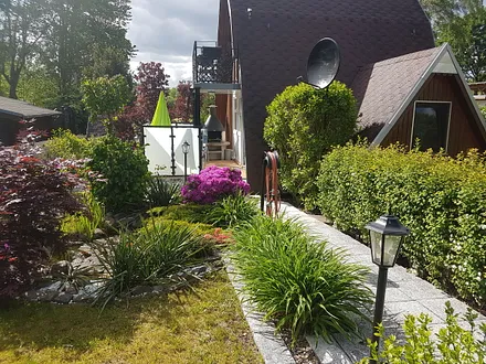 Das BIld zeigt die Vorderansicht des Finnhauses mit Weg und Parkplatz direckt vor dem Haus