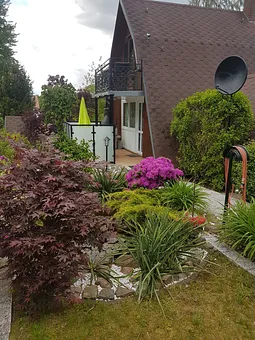 Seitenansicht des Finnhauses, mit Blick auf Terasse und Balkon.