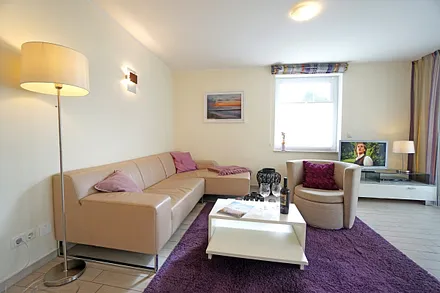 Wohnzimmer mit komfortabler Sitzgarnitur und Fernseher