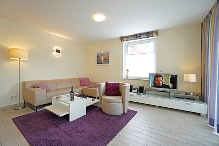 Wohnzimmer mit komfortabler Sitzgarnitur und Fernseher