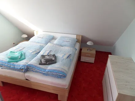 Schlafzimmer mit Doppelbett und Sideboard