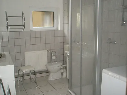 Badezimmer mit Dusche und Waschmaschine