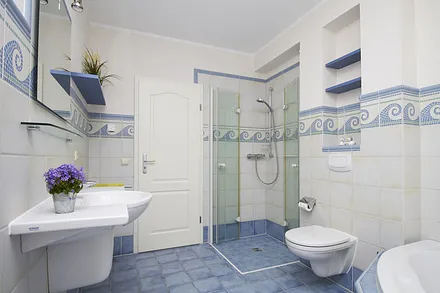 Die ebenerdige Dusche verfügt über eine Thermostat-Brausebatterie.