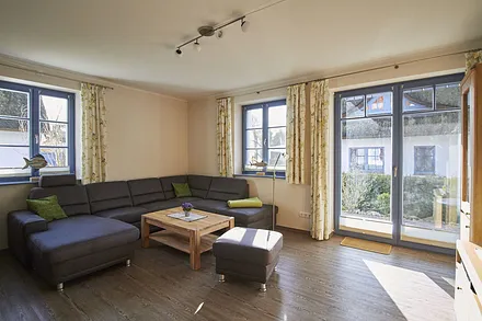 Das Wohnzimmer ist hell und lichtdurchflutet. Die große bequeme Kuschelcouch sorgt für Entspannung und Bequemlichkeit.