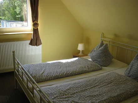 Schlafzimmer mit Doppelbett und begehbarem Kleiderschrank