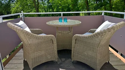 Balkon mit bequemen Sesseln und Esstisch