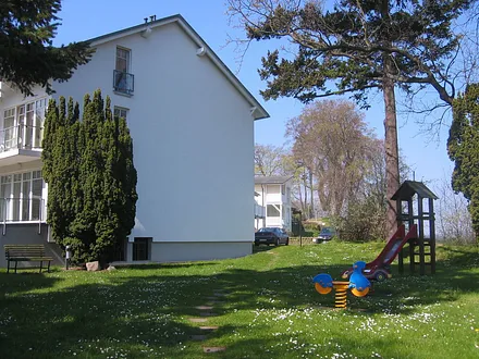 Im schönen Garten mit altem Baumbestand und einer großzügigen Rasenfläche finden Sie gleich neben der Wohnung einige Kinderspielgeräten. 