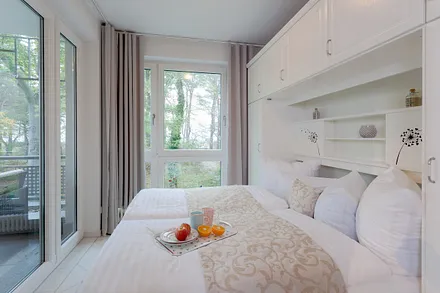 Schlafzimmer mit Doppelbett mit angrenzendem Balkon