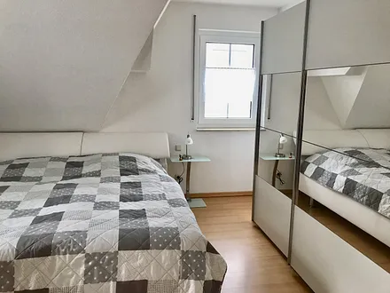Schlafzimmer mit Doppelbett und großem Schrank