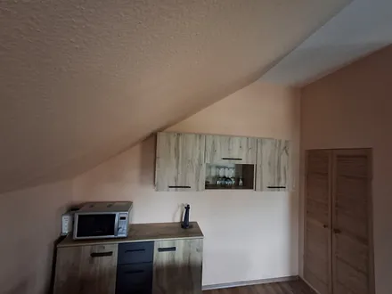 Küchenbereich mit Mikrowelle, Kaffeemaschine und diversen anderen Geräten 