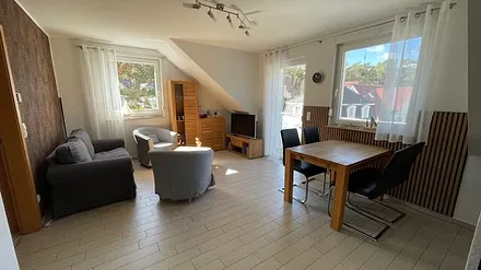 Helles gemütliches Wohnzimmer mit Smart-TV, Essbereich und Balkon