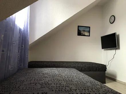 Ein kleines Flachbildfernsehgerät gehört ebenfalls zur Ausstattung des zweiten Schlafzimmers. 