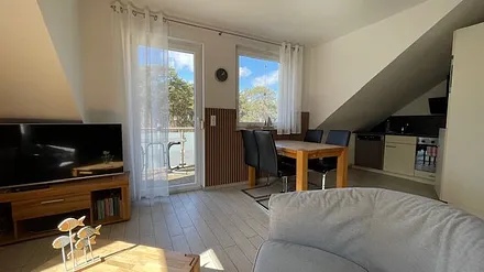 Wohnbereich mit Smart-TV, Essbereich und Balkon