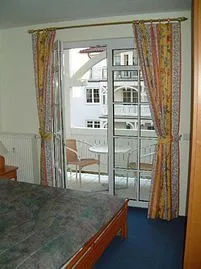 Schlafzimmer mit bequemem Doppelbett und Balkon