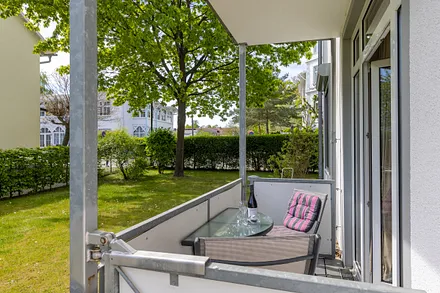 Der möblierte Balkon kann zum Austritt auf die Wiese geöffnet werden.