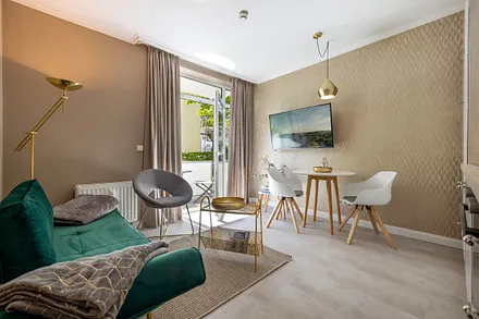 Das Wohnzimmer mit TV, WLAN und Küchenzeile hat einen Austritt zum Balkon.