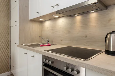 Die Küchenzeile mit Ceranfeld, Backofen, Geschirrspüler, Kühlschrank mit Gefrierfach, Kaffeemaschine, Wasserkocher, Toaster, Geschirr etc.