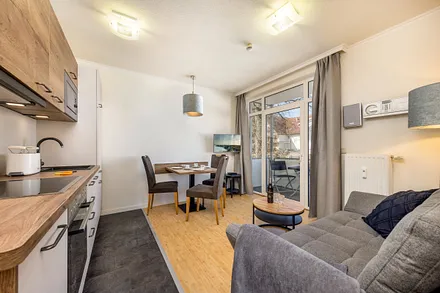 Das Wohnzimmer mit TV, Stereo-Anlage mit CD-Player und Austritt zum möblierten Balkon.