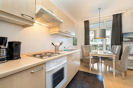 Hier der Blick von der Küchenzeile (mit 4-Platten-Herd, Backofen, Kühlschrank mit Gefrierfach, Kaffeemaschine, Wasserkocher und Toaster) zum Eßbereich.