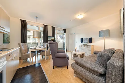 Das Wohnzimmer mit TV, Stereoanlage und kostenfreiem WLAN hat einen Austritt zum großen, möblierten Balkon.