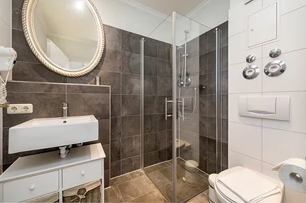 Das moderne Bad hat Echtglasdusche, WC und Fön. 