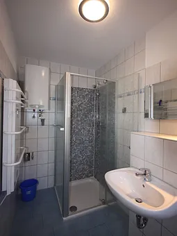 Bad mit tiefer Mosaikdusche und Handtuchwärmer
