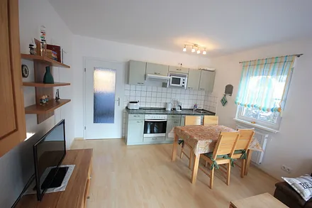 Esstisch und Küchenzeile mit Ofen und Mikrowelle