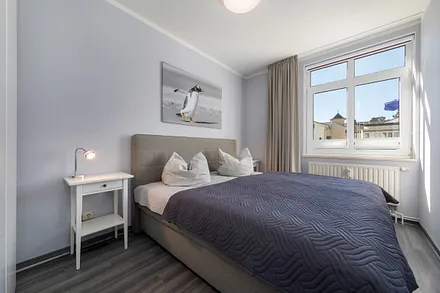 Das Schlafzimmerfenster hat Sichtschutzplissees und ein Innenrollo für die Verdunkelung.