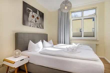 Das Schlafzimmer mit Doppelbett und Sichtschutzplissees am Fenster.