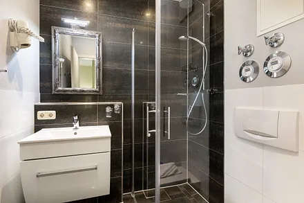 Das schicke Bad hat eine bodengleiche Echtglasdusche, WC und Fön.