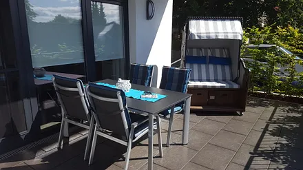 Goße Süd-West-Terrasse mit Strandkorb und Gartenmöbeln