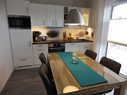 Voll ausgestattete Küche mit Esstisch