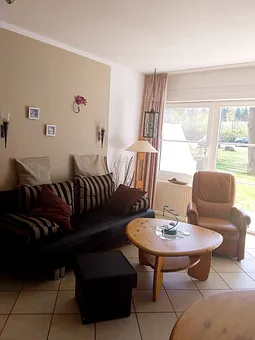 Wohnzimmer mit Blick zum hinteren Parkplatz mit Parkanlage