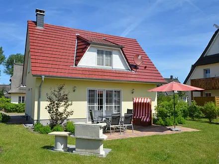 Gartenansicht mit Terrasse, Strandkorb und Grill