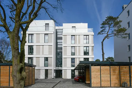 Hier die rückwärtige Ansicht der Villa. Ein Parkplatz im Carport ist inklusive. Es gibt eine Ladestation für Elektroautos. Fahrräder können in ein separates Fahrradhäuschen eingestellt werden.