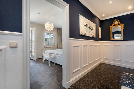 Blick vom Flur mit Garderobe in das Schlafzimmer.