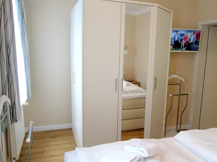Möblierung Schlafraum, großer Kleiderschrank, TV mit Schwenkarm.