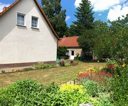 Blick auf den Giebel mit Wiese und Blumen