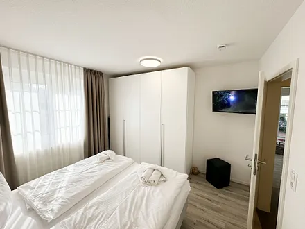 Schlafzimmer mit Kleiderschrank und TV