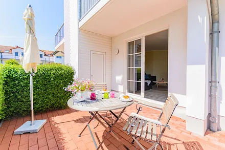 bestuhlte Terrasse durch eine Hecke geschützt