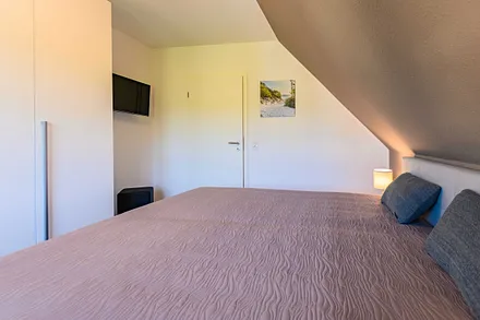 zweites Schlafzimmer mit Kleiderschrank und TV