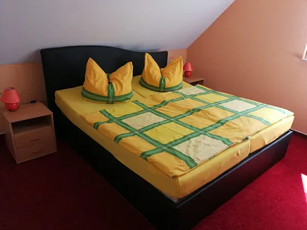 Schlafzimmer mit Doppelbett und Platz für Babybettchen