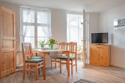 Wohnzimmer mit Esstisch und Flachbildfernseher