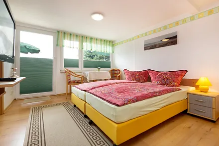 Herzlich willkommen im Urlaub! Hier im Bild der Wohn-/Schlafraum mit Ausgang zur Dachterrasse. Die Fenster sind mit Verdunkelungsplissees ausgestattet.