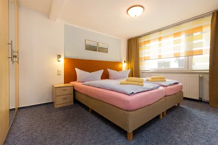 Das Schlafzimmer hat Doppelbett, Kleiderschrank und Verdunkelungsgardinen.