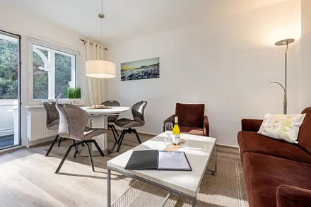 Das Wohnzimmer mit Eßbereich und Austritt zum Balkon.