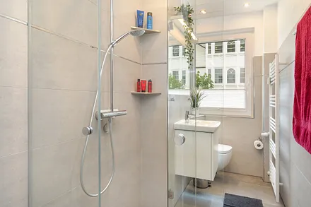 Das moderne Bad mit Regendusche und WC. Die Dusche ist bodengleich.