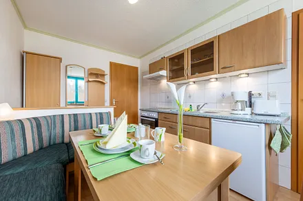 Die Küchenzeile hat Backofen, Cerankochfeld, Kühlschrank mit Gefrierfach ...