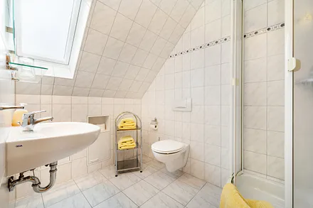 Das Bad bietet Dusche, WC und Waschbecken.